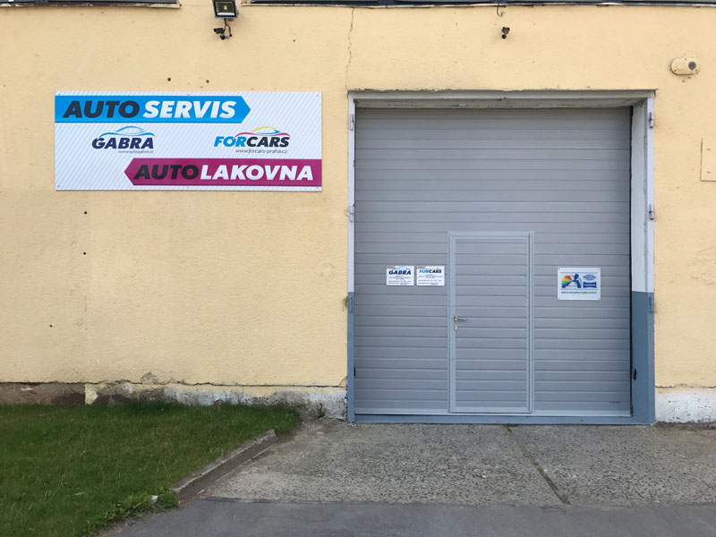 Vjezdová vrata do dílny s označením autoservisu a lakovny